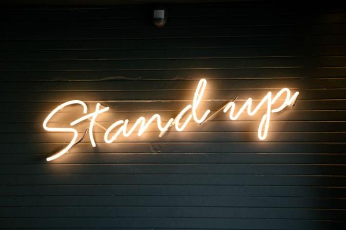 Neon sign saying "Stand up"